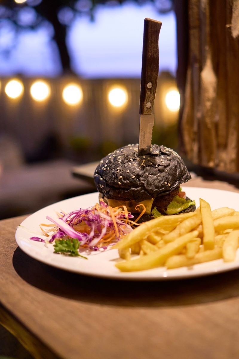 Black-bun burger with fries at dusk