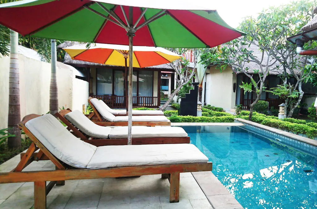Poolside loungers under colorful umbrellas at JOJE Bungalows