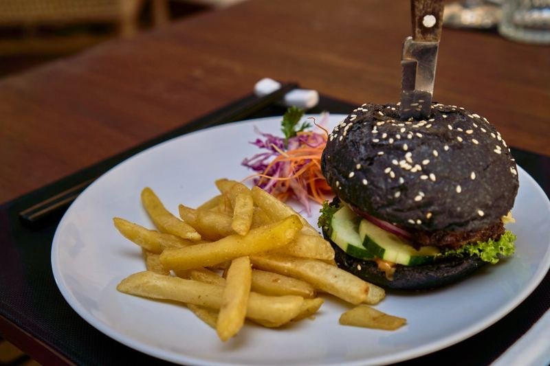 Black-bun burger with crisp fries, close up