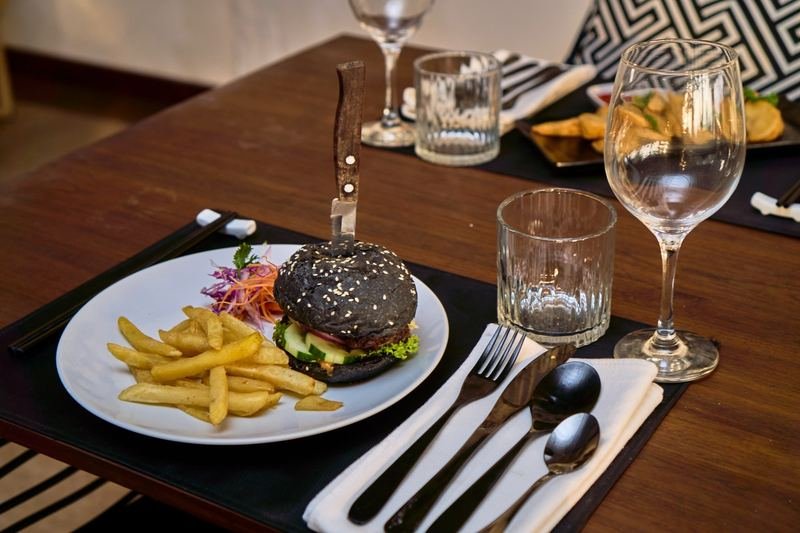 Black-bun burger and fries, table set for two