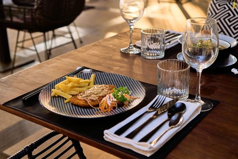Crumbed cutlet with fries and salad, golden hour