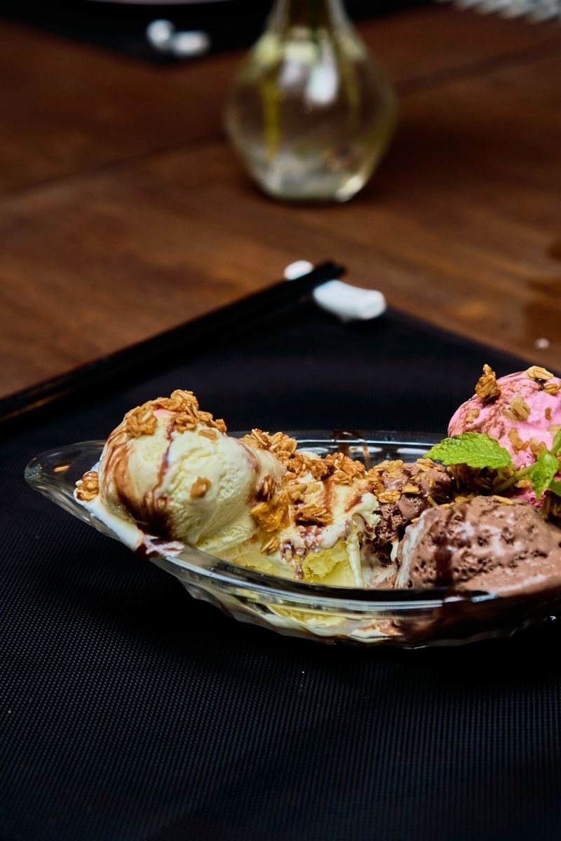 Ice cream scoops with granola and chocolate sauce