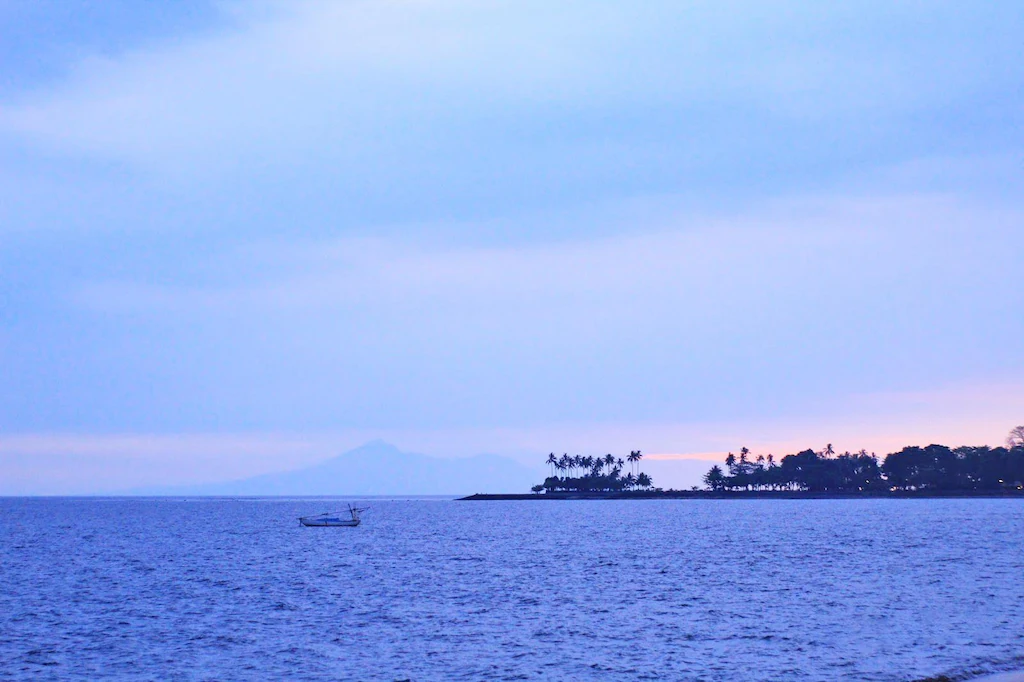 Senggigi beach at dusk with fishing boat